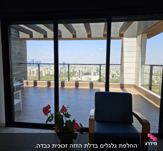 מרפסת עם נוף עירוני דרך חלון זכוכית